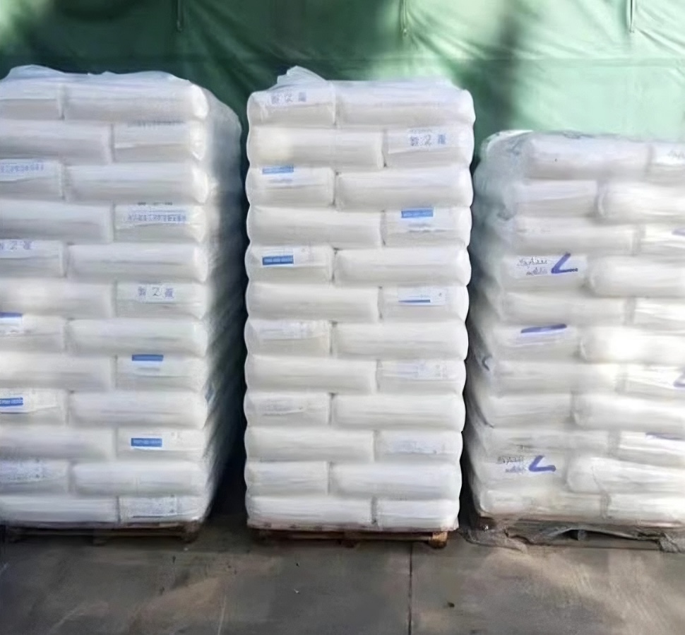 Multiple pallets stacked with white polyethylene plastic resin sacks in warehouse storage